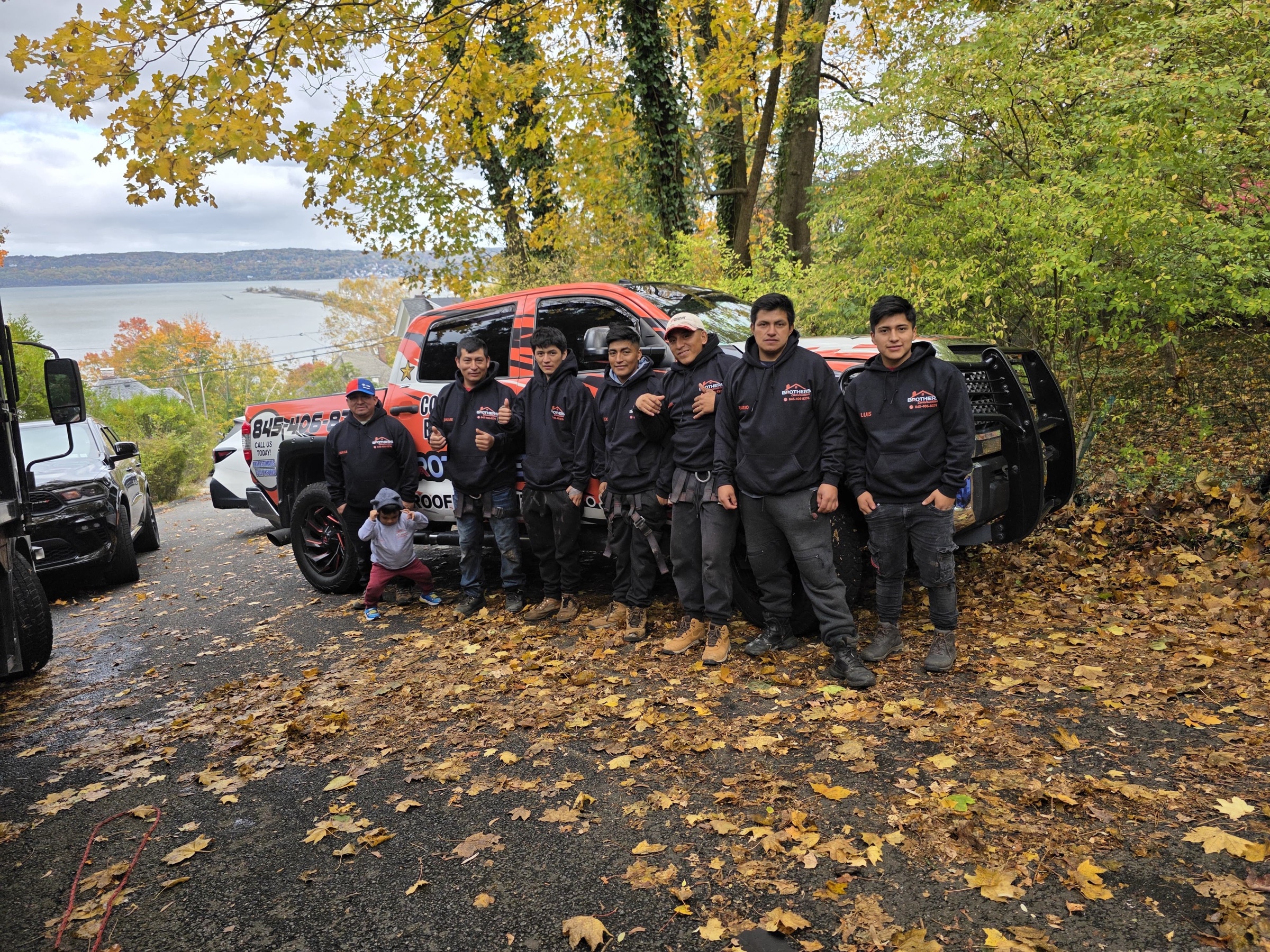 Local business team in custom hoodies beside its lettered vehicle